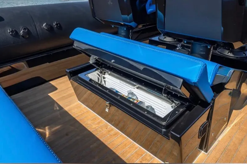 Slide: The Image of 2025 Technohull 38 Gran boat with open storage compartment, blue seating, and wooden deck. - 29
