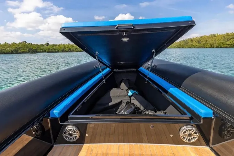 Slide: The Image of Open storage compartment on 2025 Technohull 38 Gran boat, with scenic water backdrop. - 9