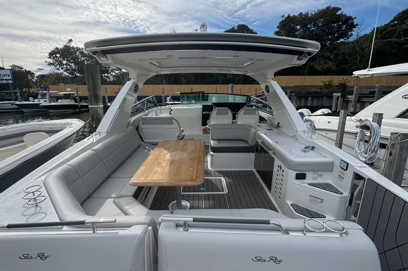 Slide: The Image of 2025 Sea Ray SLX 400 Outboard luxury boat interior with seating and table. - 17