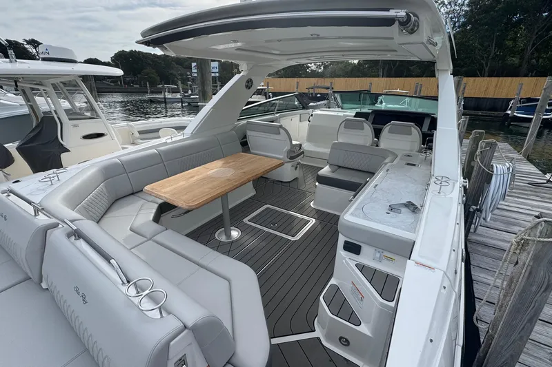 Slide: The Image of 2025 Sea Ray SLX 400 Outboard luxury boat interior with seating and table. - 18