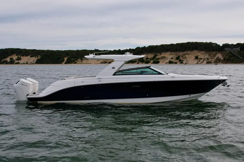 Slide: The Image of 2025 Sea Ray SLX 400 Outboard boat on water, scenic shoreline background. - 2