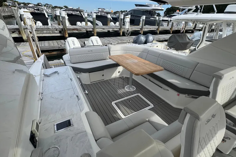 Slide: The Image of 2025 Sea Ray SLX 400 Outboard luxury boat interior with elegant seating and wooden table. - 23