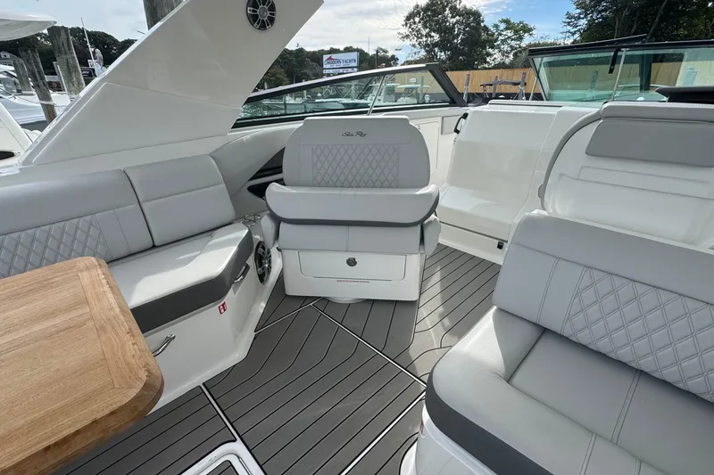 Slide: The Image of 2025 Sea Ray SLX 400 Outboard interior with luxurious seating and wooden table. - 26