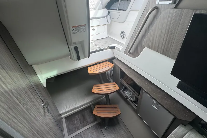 Slide: The Image of 2025 Sea Ray SLX 400 Outboard interior with wooden steps and modern design. - 35