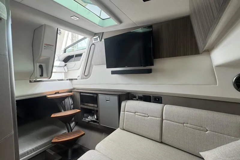 Slide: The Image of Interior of 2025 Sea Ray SLX 400 Outboard with modern seating and TV. - 38