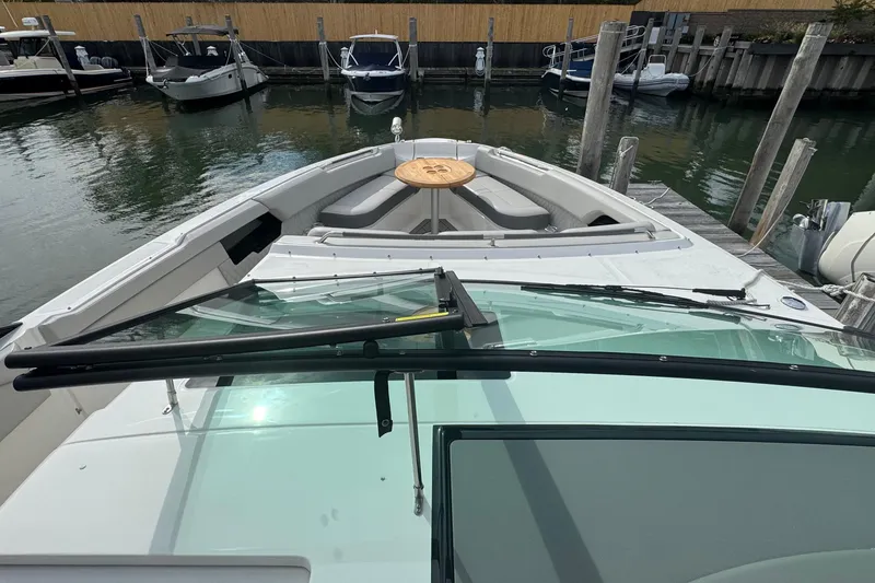 Slide: The Image of 2025 Sea Ray SLX 400 Outboard boat docked, showcasing spacious deck and seating area. - 43