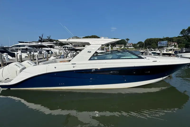 Slide: The Image of 2025 Sea Ray SLX 400 Outboard boat docked in marina under clear blue sky. - 8