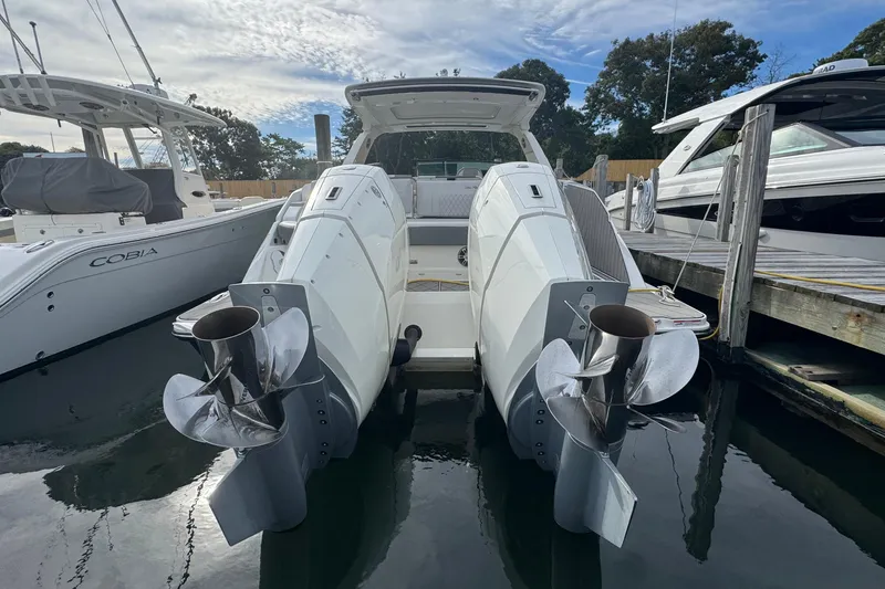 Slide: The Image of 2025 Sea Ray SLX 400 Outboard docked with dual engines, surrounded by other boats. - 9