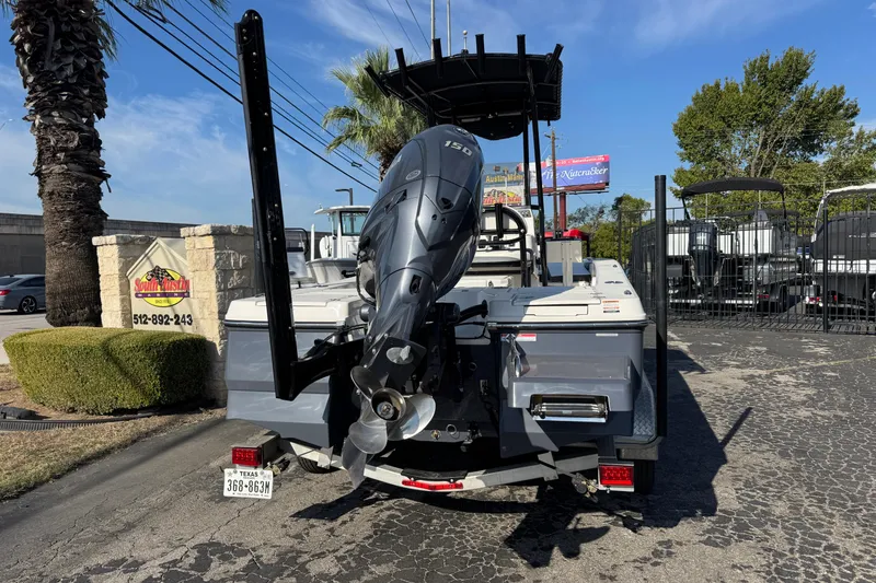 Slide: The Image of 2023 Robalo 206 Cayman boat with outboard motor, parked outdoors at a dealership. - 1
