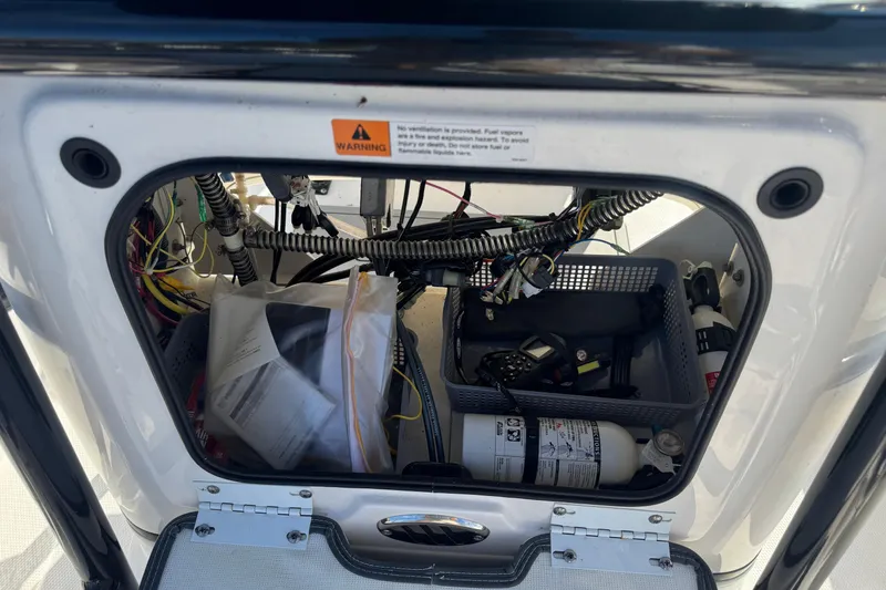 Slide: The Image of 2023 Robalo 206 Cayman boat storage compartment with wiring and equipment. - 22