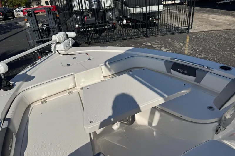 Slide: The Image of 2023 Robalo 206 Cayman boat interior with seating and table, parked outdoors. - 37