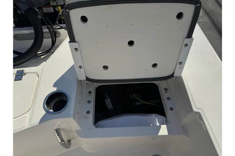 Slide: The Image of 2023 Robalo 206 Cayman boat storage compartment with open hatch and visible battery. - 40