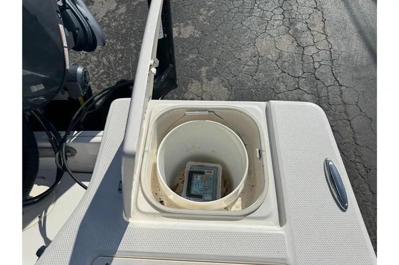 Slide: The Image of 2023 Robalo 206 Cayman boat storage compartment with open lid and container inside. - 44