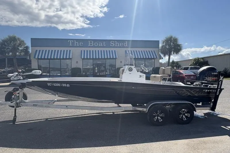 Slide: The Image of 2022 Xpress H22B Bay boat on trailer outside The Boat Shed dealership. - 0