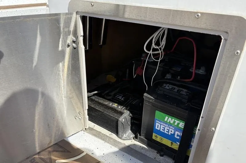Slide: The Image of Open compartment on 2022 Xpress H22B Bay boat showing marine deep cycle batteries. - 15