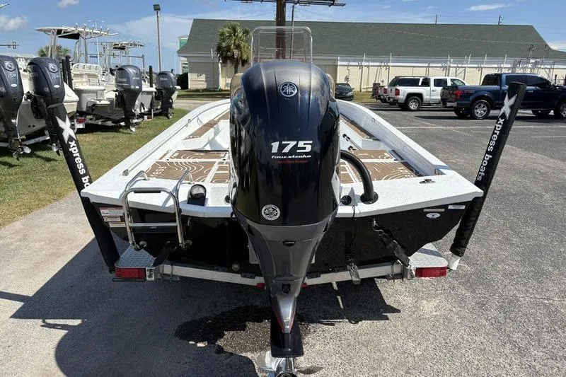 Slide: The Image of 2022 Xpress H22B Bay boat with Yamaha 175 engine, parked outdoors. - 2