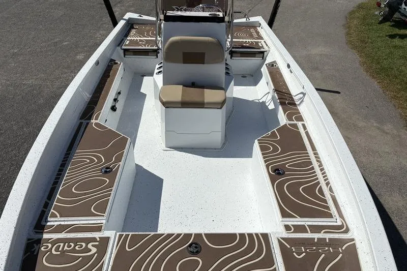 Slide: The Image of 2022 Xpress H22B Bay boat interior with brown SeaDek flooring and central seating. - 23