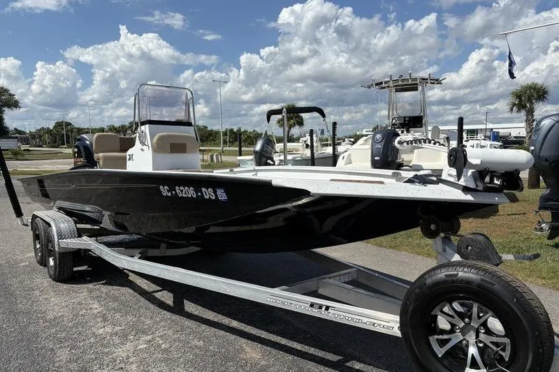 Slide: The Image of 2022 Xpress H22B Bay boat on trailer under a partly cloudy sky. - 5