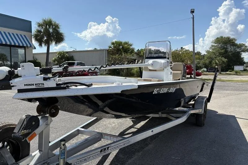 Slide: The Image of 2022 Xpress H22B Bay boat on trailer with Minn Kota motor, parked outdoors. - 7