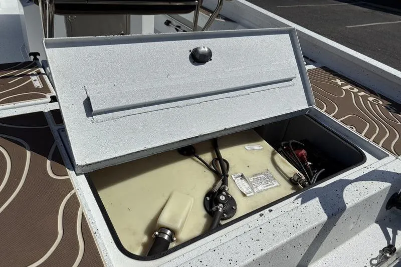 Slide: The Image of Open storage compartment on 2022 Xpress H22B Bay boat, showing internal components. - 9
