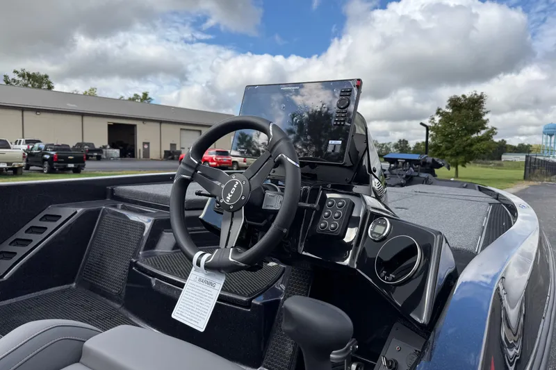 Slide: The Image of 2026 iKon LXE21 boat dashboard with steering wheel and control panel under cloudy sky. - 11