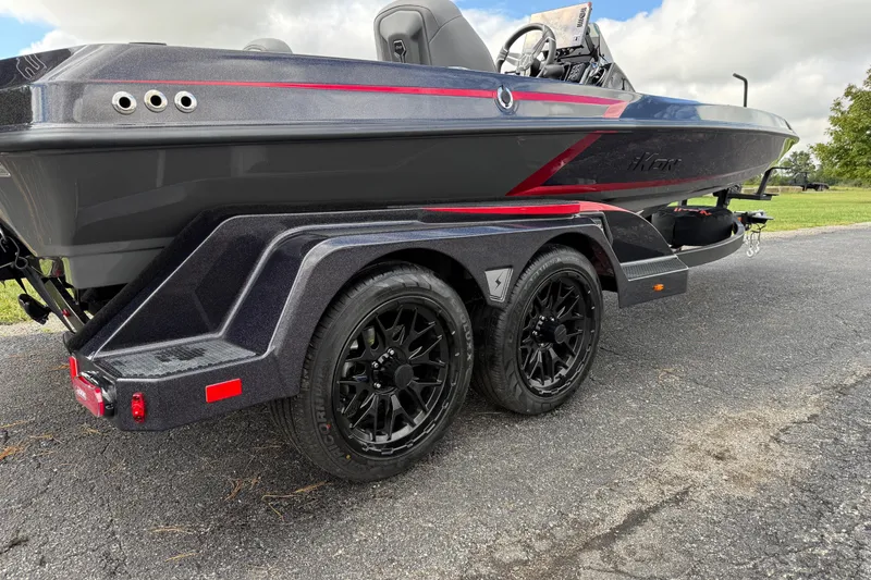 Slide: The Image of 2026 iKon LXE21 boat on trailer with sleek design and black wheels. - 12