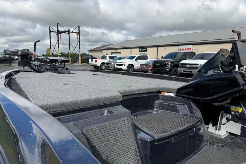 Slide: The Image of 2026 iKon LXE21 boat with gray deck, parked near dealership under cloudy sky. - 18