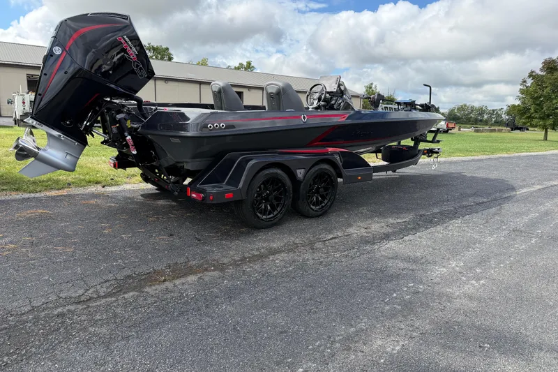 Slide: The Image of 2026 iKon LXE21 boat on trailer, parked outdoors, featuring sleek design and powerful engine. - 2