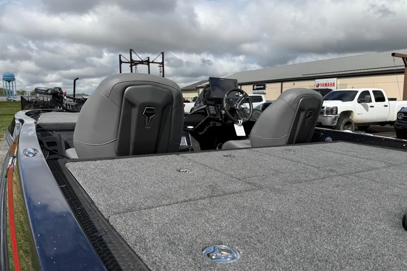 Slide: The Image of 2026 iKon LXE21 boat interior with gray seats and steering console, parked outdoors. - 20