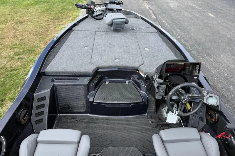 Slide: The Image of 2026 iKon LXE21 boat interior with steering wheel, control panel, and seating on a paved surface. - 21