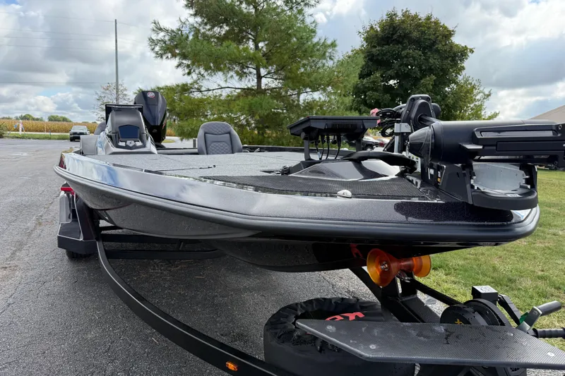 Slide: The Image of 2026 iKon LXE21 boat on trailer, parked outdoors with trees in background. - 7