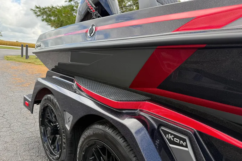 Slide: The Image of 2026 iKon LXE21 boat with sleek red and black design on a trailer. - 9