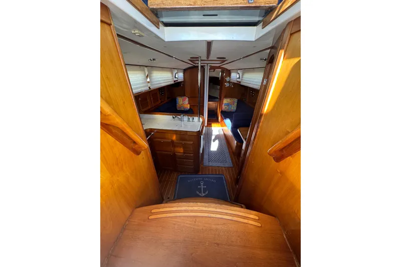 Slide: The Image of Interior of 2005 Sabre 386 sailboat, featuring wooden cabinetry and cozy seating area. - 11
