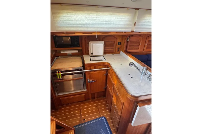 Slide: The Image of 2005 Sabre 386 yacht interior kitchen with wooden cabinetry and modern appliances. - 13
