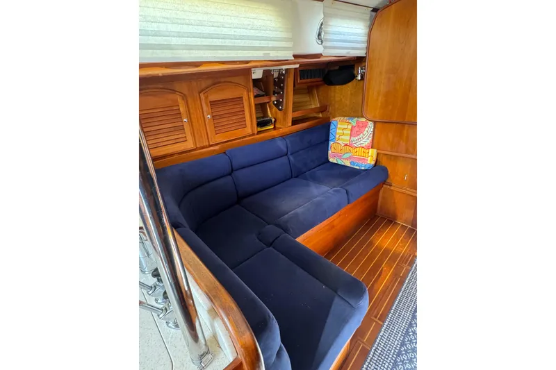 Slide: The Image of Interior of 2005 Sabre 386 yacht with blue cushioned seating and wooden cabinetry. - 18