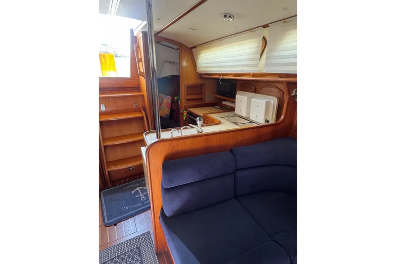 Slide: The Image of Interior of 2005 Sabre 386 yacht with wooden cabinetry and blue seating. - 19