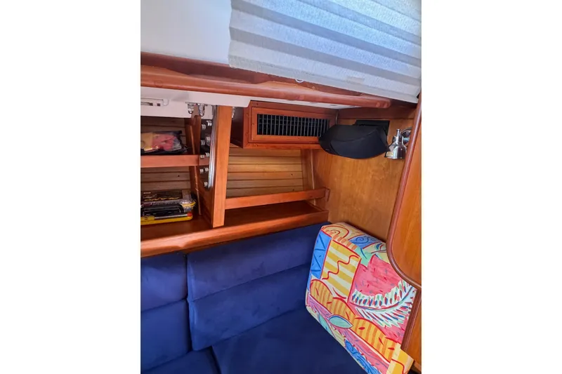 Slide: The Image of Interior of 2005 Sabre 386 sailboat with wooden shelves and colorful cushion. - 24