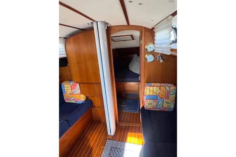 Slide: The Image of Interior of 2005 Sabre 386 sailboat with wood paneling and colorful cushions. - 25
