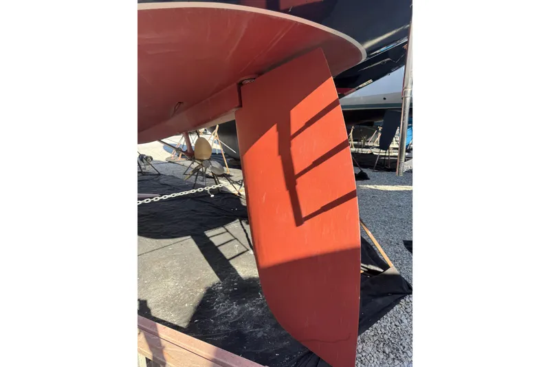 Slide: The Image of Rudder of 2005 Sabre 386 sailboat on dry dock, showing red paint and shadow. - 39