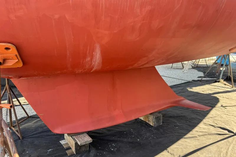Slide: The Image of Red hull of 2005 Sabre 386 sailboat on stands, showing keel detail. - 42