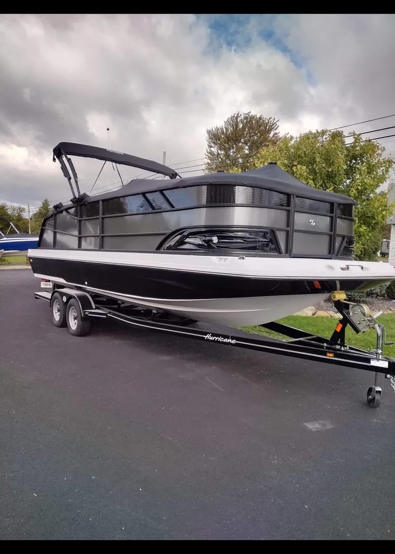 Slide: The Image of 2023 Hurricane FunDeck 2360 SBC boat on trailer, parked outdoors. - 2