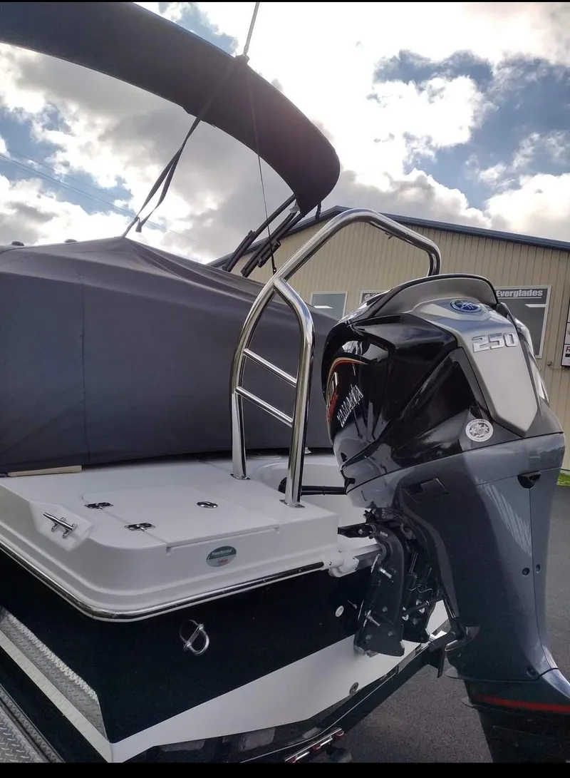 Slide: The Image of 2023 Hurricane FunDeck 2360 SBC boat with powerful outboard motor, docked under cloudy sky. - 3