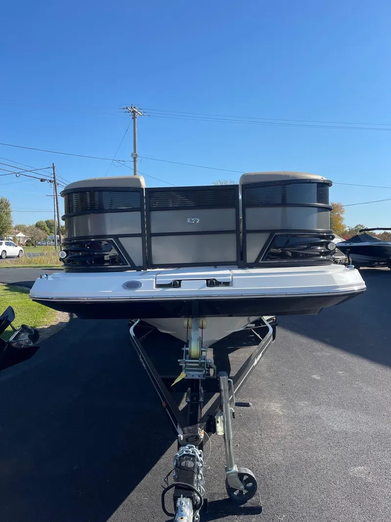 Slide: The Image of 2023 Hurricane FunDeck 2360 SBC boat on trailer, parked outdoors under clear blue sky. - 6