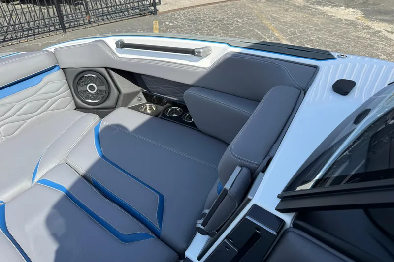 Slide: The Image of 2026 Supra SA 450 boat interior with gray and blue seating, speaker, and cup holders. - 53