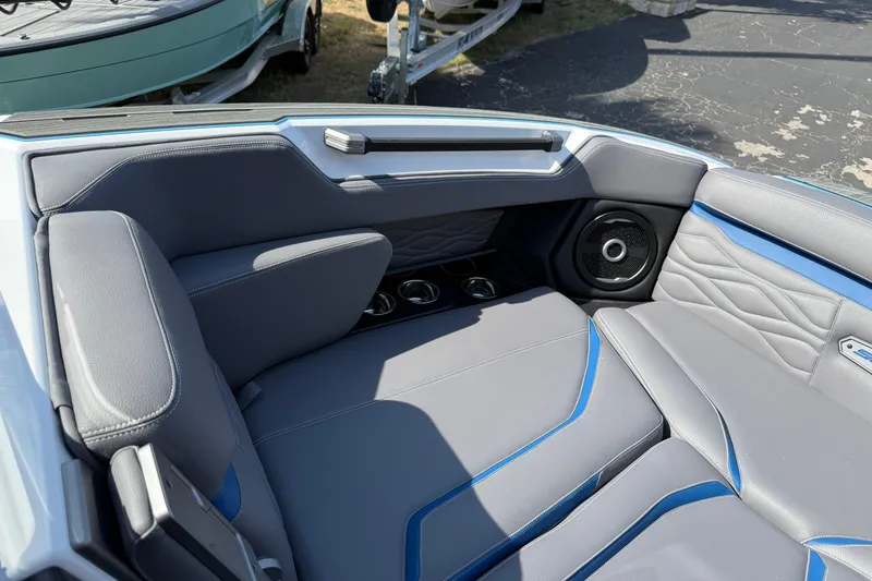 Slide: The Image of 2026 Supra SA 450 boat interior with gray and blue seating, cup holders, and speaker. - 54