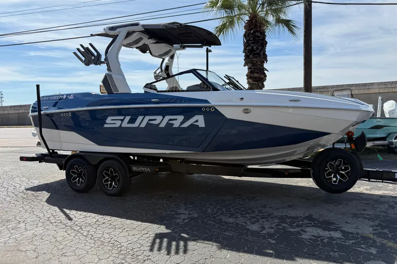 Slide: The Image of 2026 Supra SA 450 boat on trailer, parked outdoors under clear sky. - 58