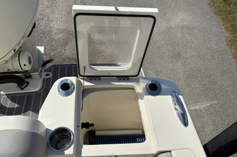 Slide: The Image of 2026 Scout 240 XSF boat with open storage compartment and cup holders. - 11