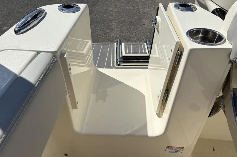Slide: The Image of 2026 Scout 240 XSF boat interior with open storage compartment and cup holders. - 12