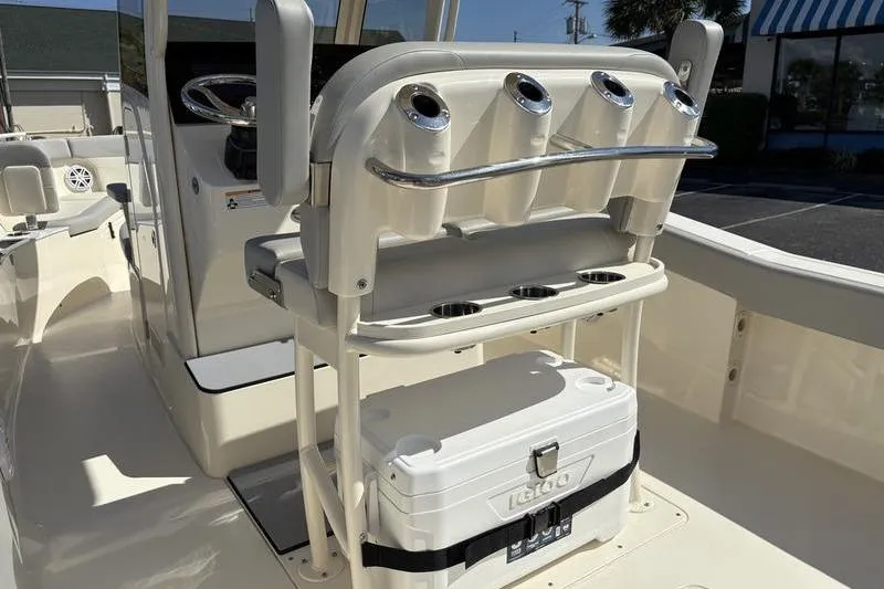 Slide: The Image of 2026 Scout 240 XSF boat interior with rod holders and cooler storage. - 15
