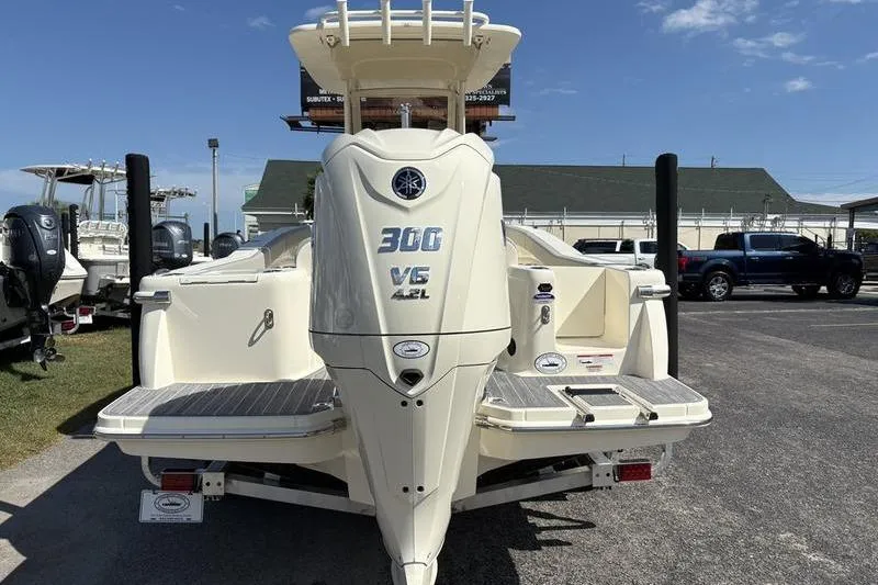 Slide: The Image of 2026 Scout 240 XSF boat with Yamaha 300 V6 engine, parked outdoors. - 2